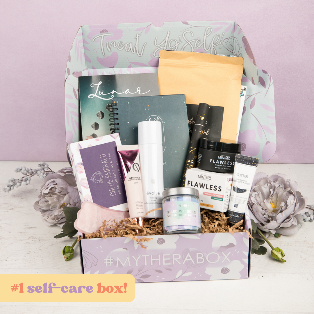 #1 self care box. Photo of past Lunar themed therabox on light purple background. Range of items are displayed such as Rose Quartz gua sha, body butter, toner, journal, flawless minobo scrub, incense and face cream