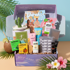 The TheraBox Paradise box features WARDA SKINCARE Dragonfruit & BHA Tropical Detox Clay Mask, BUFFOUT Callus Eraser Scrub Gel, ANIHANA Body Wash Bar, POOFY ORGANICS The Sunscreen Stick SPF 30+, YES TO Watermelon Refreshing Paper Mask, ANTHONY Lip Balm SPF 25, GLOW IS HERE Vitamin C Chewable, HAPPY SHOPPE Cactus Trinket Dish, and FAMILIUS X KATHRYN THOMPSON’s Drops of Awesome.
