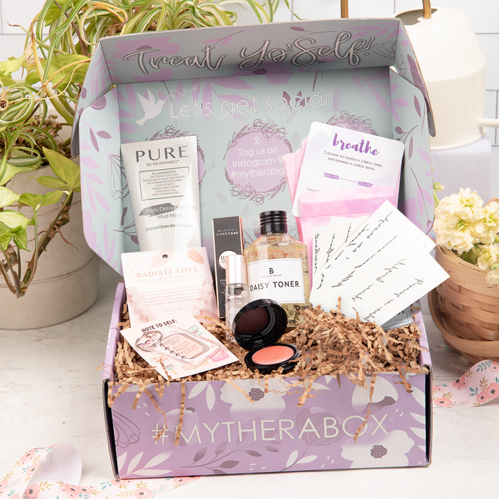 TheraBox Adore box featuring Mudmasky | Body Detox Recovery Mud Mask, Inked By Dani | Mantra Pack, Without Contrast | Rose Quartz Essential Oil, Mally Beauty| Bounce Back Rose Petal Blush, &nbsp;AYNIL | Rose Quartz And Lava Bead Diffuser Bracelet, The Happy Shoppe | Note To Self: Self Love Keychain, Beauty Papier | Daisy Toner, and Healthy Chicks | Spark Your Bliss Deck