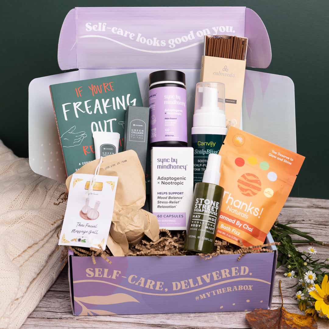 The TheraBox Awetumn box features STONE STREET SOAPHOUSE Hay Ho! Body Mist, MINDHONEY Sync Adaptogenic x Nootropics, LEADERS COSMETICS Green Collagen Eye Cream, HEALTH HEALING PRODUCTS LTD Thai Facial Massage Ball, CALMVEDA Palo Santo Incense Sticks, CANVIIY ScalpBliss Soothing Scalp-Purifying Foam Treatment, THANKS! NATURALS Charmed by Chai Bath Fizz, and MICROCOSM PUBLISHING’s If You’re Freaking Out, Read This: A Coping Workbook.