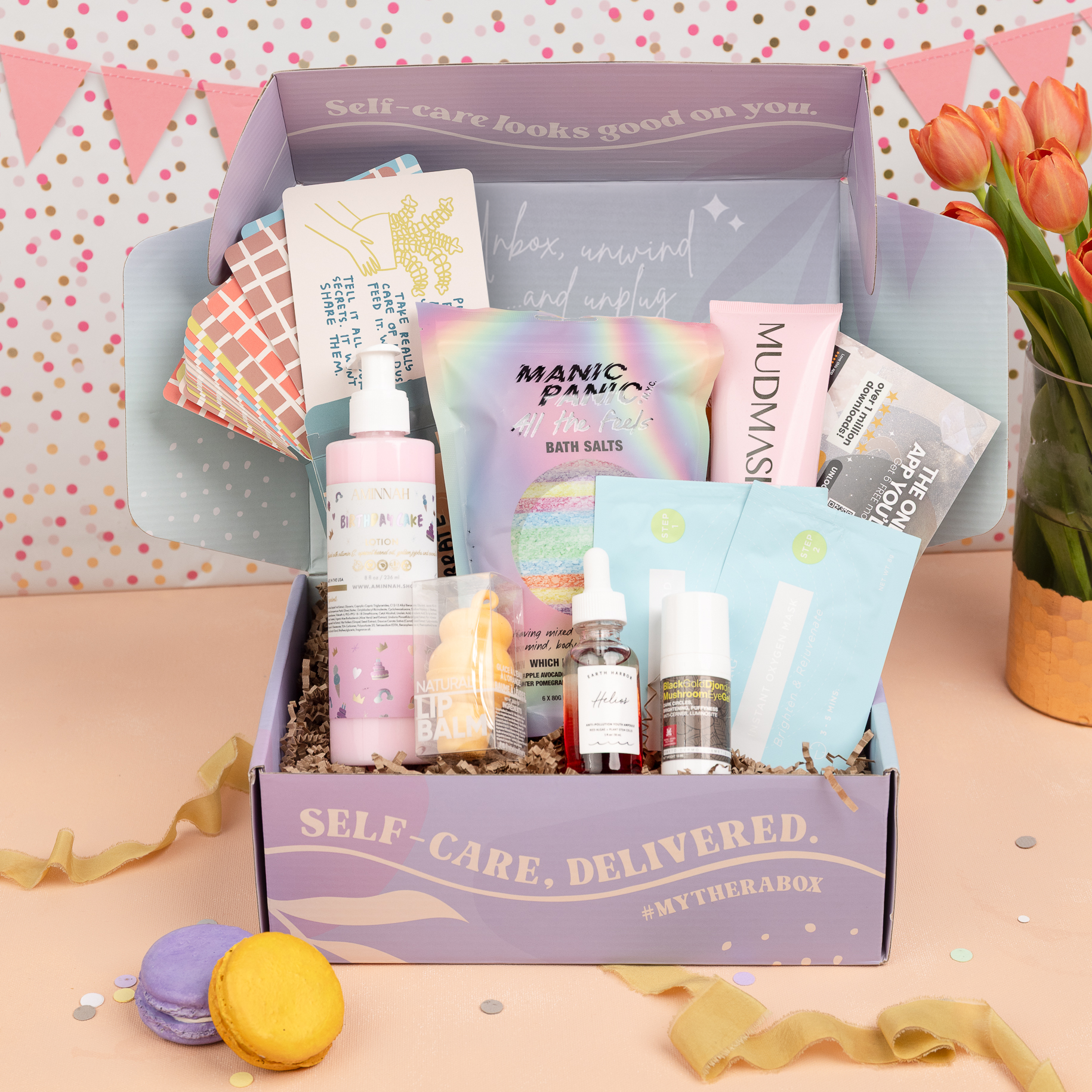 TheraBox Celebr8te Box featuring Aminnah | Birthday Cake Lotion, Earth Harbor | Helios Anti-Pollution Youth Ampoule, Ling Skincare | Instant Peeling Pad + Instant Oxygen Mask, Rebels Refinery | Ice Cream Lip Balm Orange Dreamsicle, Mudmasky | Velvety Glow Body Scrub, Morganna's Alchemy Skincare | Black Gold Mushroom Eye Gel, Manic Panic | All The Feels Bath Bomb OR Bath Salt, People You've Loved | Excuses to Celebrate Deck and Saged App | 6 Months of Saged Premium