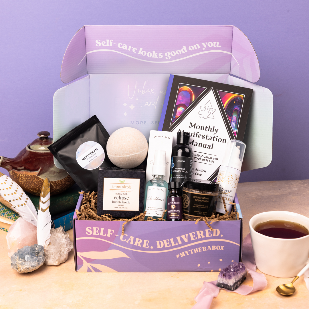 The TheraBox Ethereal box features MAGIC SKIN REPAIR Magic Facial Cleanser, EARTH HARBOR Cloudburst Balancing Gel Hydrator, TRUE MORINGA Rejuvenating Body Polish, INNATUS USA Dead Sea Magnesium Tranquility Oil, CHICORY TEA CO. Moonbeam Herbal Tea, JENNA NICOLE Eclipse Bubble Bath Bomb, KATE’S MAGIK Moon Goddess Anointing Oil, and MICROCOSM PUBLISHING’s Monthly Manifestation Manual: A 31-Day Guided Journal to Create Your Best Life.