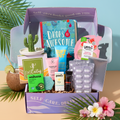 The TheraBox Paradise box features WARDA SKINCARE Dragonfruit & BHA Tropical Detox Clay Mask, BUFFOUT Callus Eraser Scrub Gel, ANIHANA Body Wash Bar, POOFY ORGANICS The Sunscreen Stick SPF 30+, YES TO Watermelon Refreshing Paper Mask, ANTHONY Lip Balm SPF 25, GLOW IS HERE Vitamin C Chewable, HAPPY SHOPPE Cactus Trinket Dish, and FAMILIUS X KATHRYN THOMPSON’s Drops of Awesome.