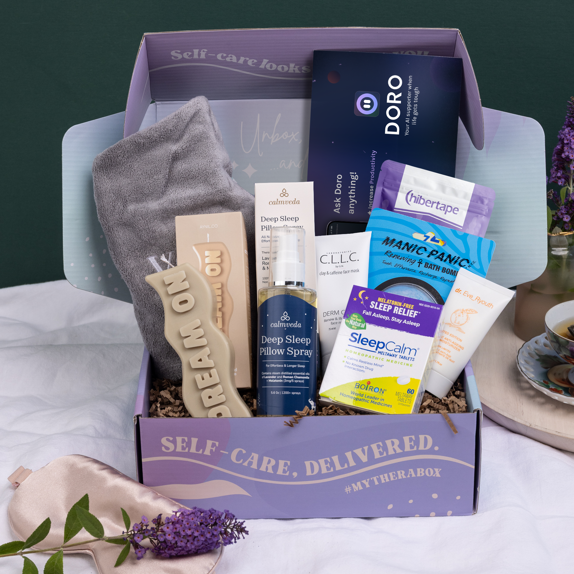 TheraBox Nightcap box featuring DR. EVE RYOUTH Vitamin C Night Moisturizer, AYNIL CO. Dream On Candle, CLLC BY G.N. Derm Clay Renew & Illuminate Face Mask, MANIC PANIC Bath Bomb, HIBER TAPE Lavender Blossom Mouth Tape, BOIRON SleepCalm® Meltaway Tablets, CALMVEDA Deep Sleep Pillow Spray, VOIR HAIRCARE Wash Day: Quick Dry Hair Wrap, and a DORO AI Companion 3-Month Subscription.