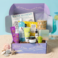 The TheraBox Sea La Vie box features STAR LABS BEAUTY 80 Hour Hydro Boost Electrolyte Moisture Boosting Serum, WATERBODY Deep Blue Sea Invigorating Face Mask, AVRY BEAUTY Gel-Ohh! Jelly Spa Bath – Pineapple Breeze, REBELS REFINERY Summer Citrus Neon Cactus Lip Balm, AYNIL CO. Sea Grass Candle, POOFY ORGANICS After Sun Spray, EEZYSUN SPF 50 with Insect Repellant, ALPHA SKIN Moisturizing Body Wash – Sea Mist, and AVANYATHI ZEPHYRA Water Alchemy Coloring Book.
